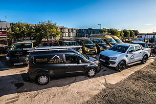 A fleet of Probuild Contracts vehicles, including a black van