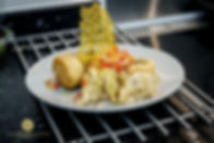 A gourmet dish on a white plate features flaky pastry