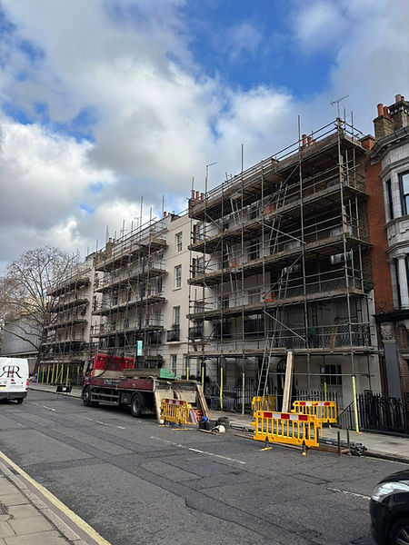 Street view of buildings under renovation, covered in scaffolding