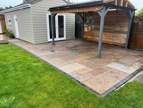A backyard patio features large, multicolored stone tiles