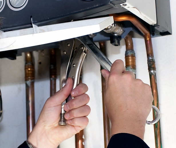 Hands using pliers on pipes