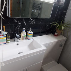 Modern bathroom with a white sink, soap dispensers, and a toothbrush holder.