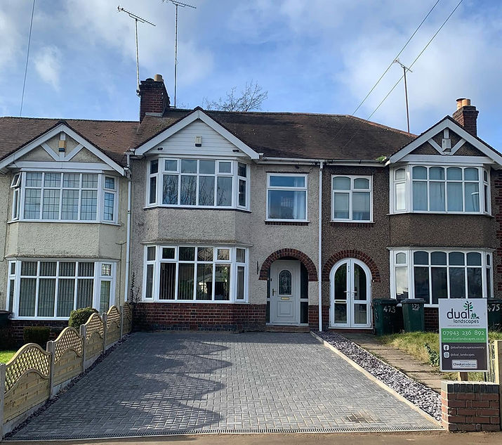 A newly installed grey block-paved driveway in front of a traditional 1930s suburban semi-detached house