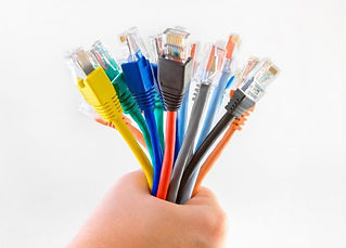 A hand holding multiple colorful Ethernet cables