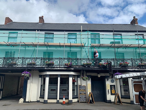 Historic building under renovation with turquoise scaffolding