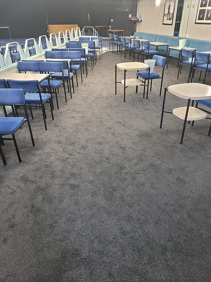 A large indoor social venue with grey carpeting