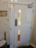 A white commercial double fire door featuring an asymmetric split
