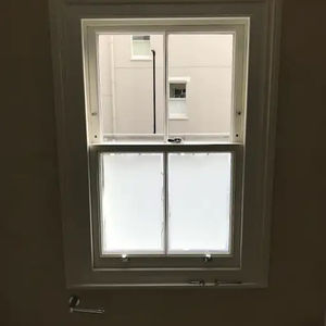 A small, white-framed double-hung window with frosted lower panes 