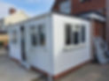 A newly built white-panelled home extension with multiple windows and an open door