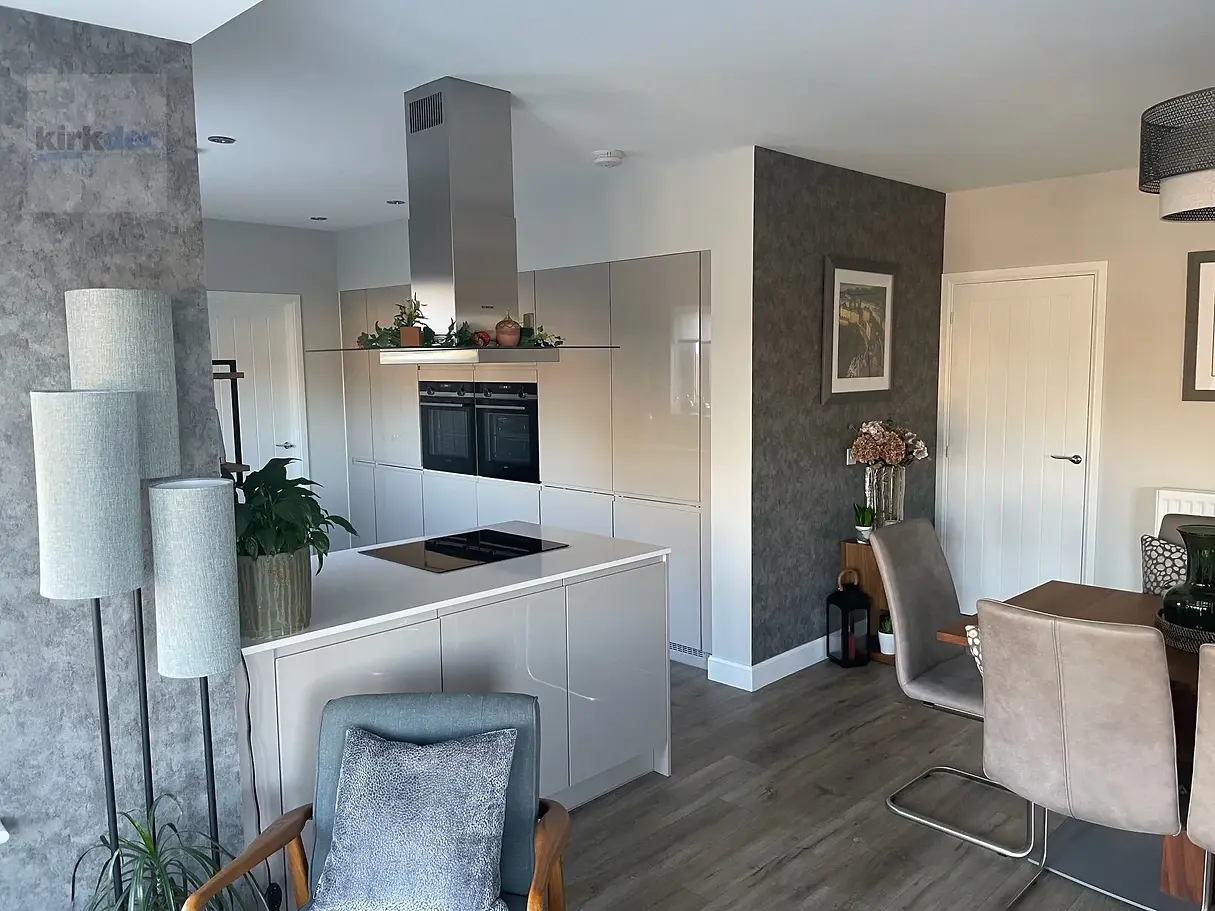 Modern kitchen-dining area. Light-coloured walls, wood floors, and cozy seating