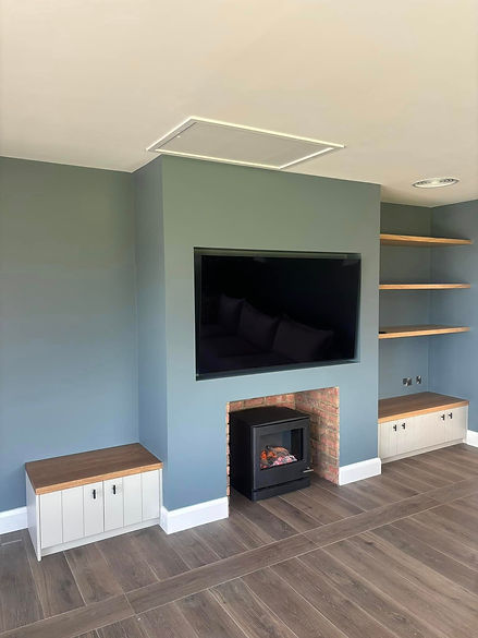 Modern living room with gray wood flooring, blue walls, and a central black electric fireplace