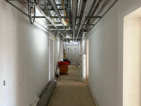 An internal corridor under construction with white plastered walls