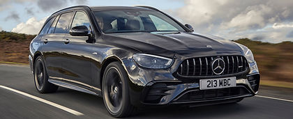 A sleek black Mercedes-Benz wagon drives on a highway