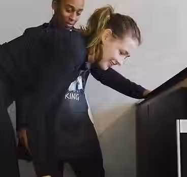 Student in Life Skills centre apartment learning how to unload and load a dishwasher