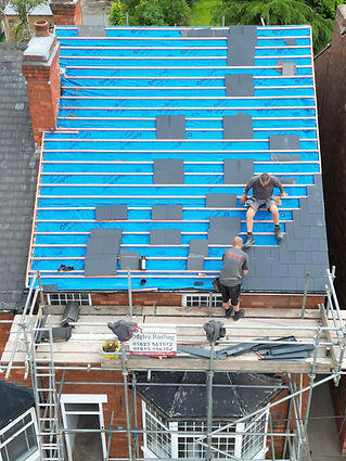Roofers installing slate tiles