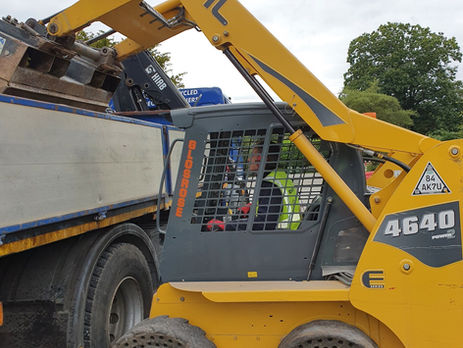 Yellow skid steer loader working