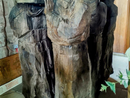 bronze statue of monks carrying a coffin