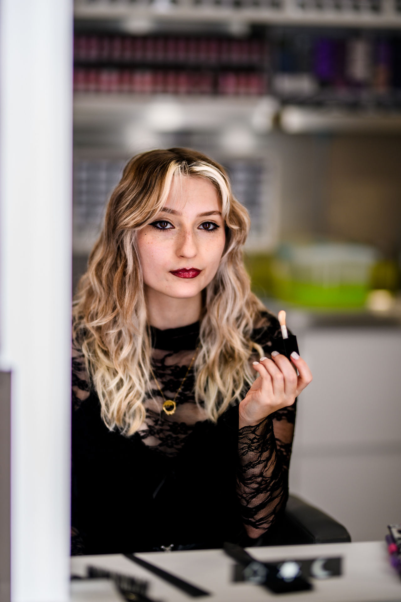 branding photo in front of mirror of woman after she just put lipstick on