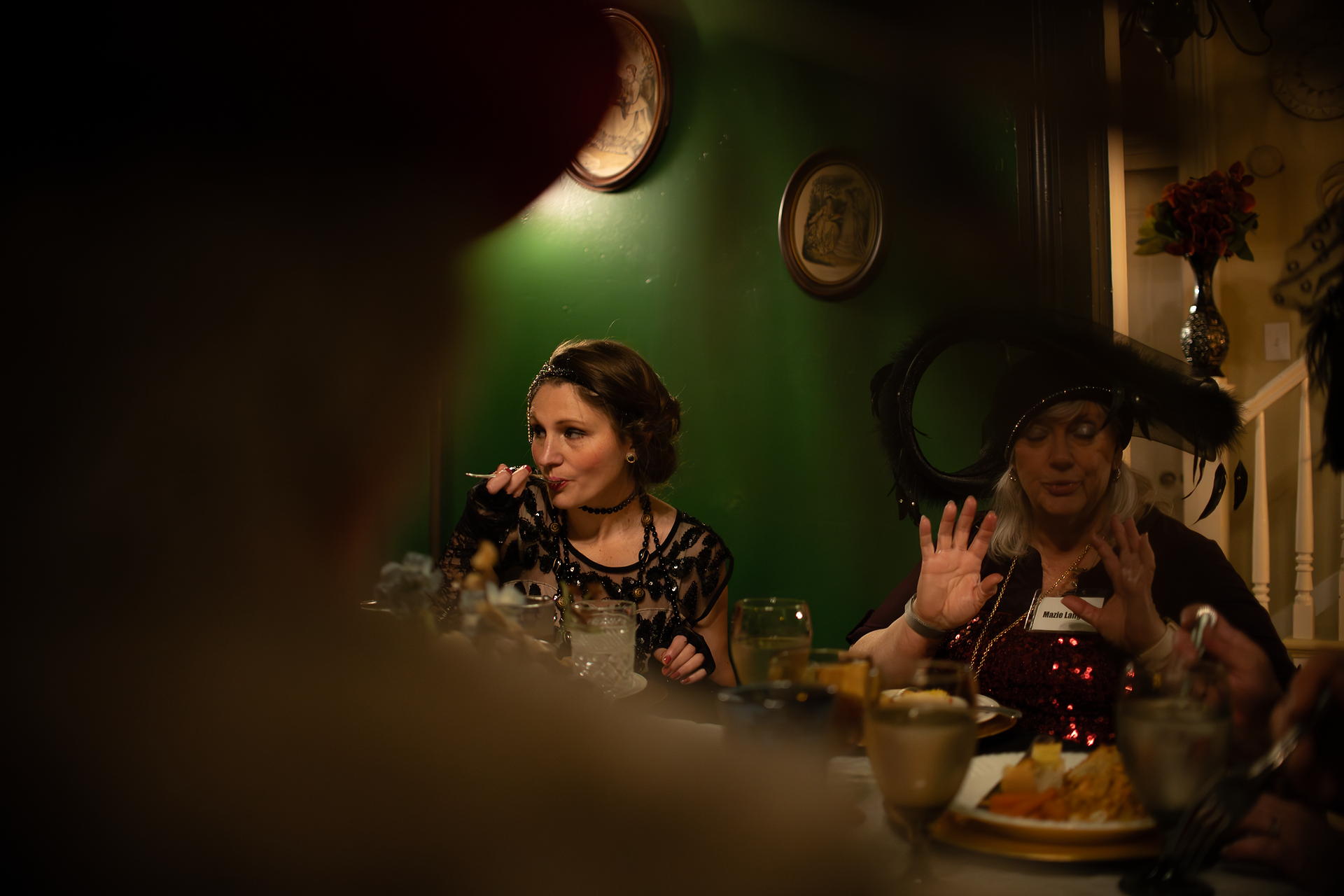 creative shot of guests eating at dinner table at Whistlestop Manor's murder mystery dinner