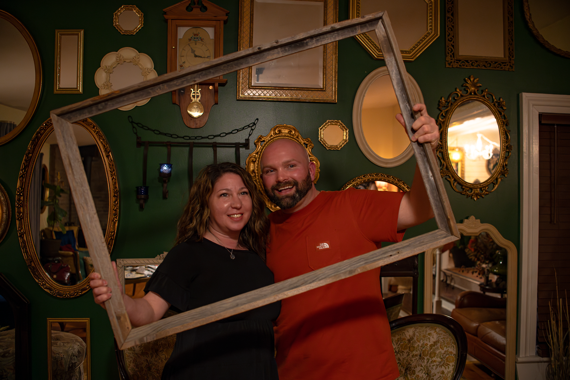 Couple holding a picture frame around their faces