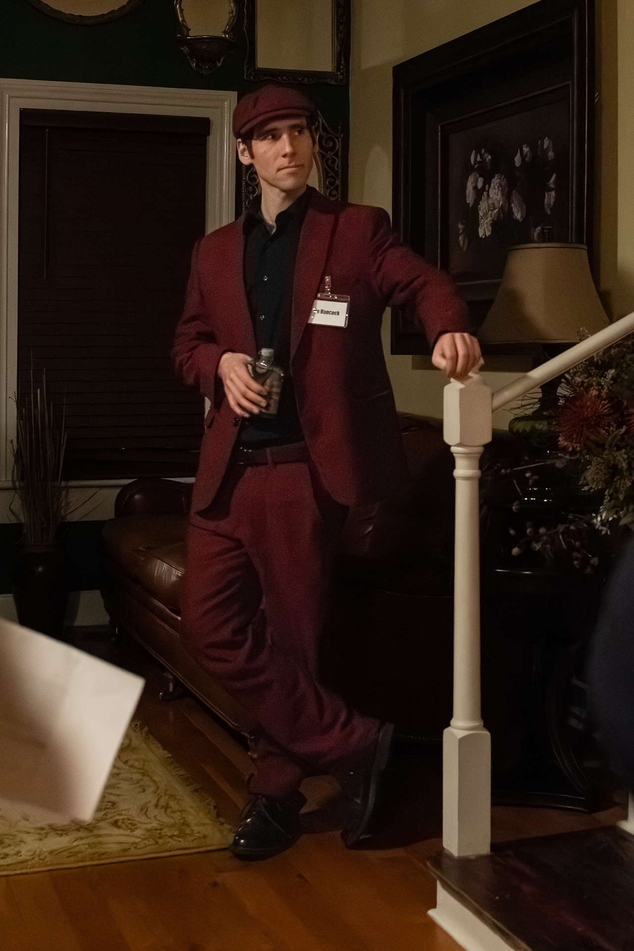 man dressed in a red suit with hand on stair railing