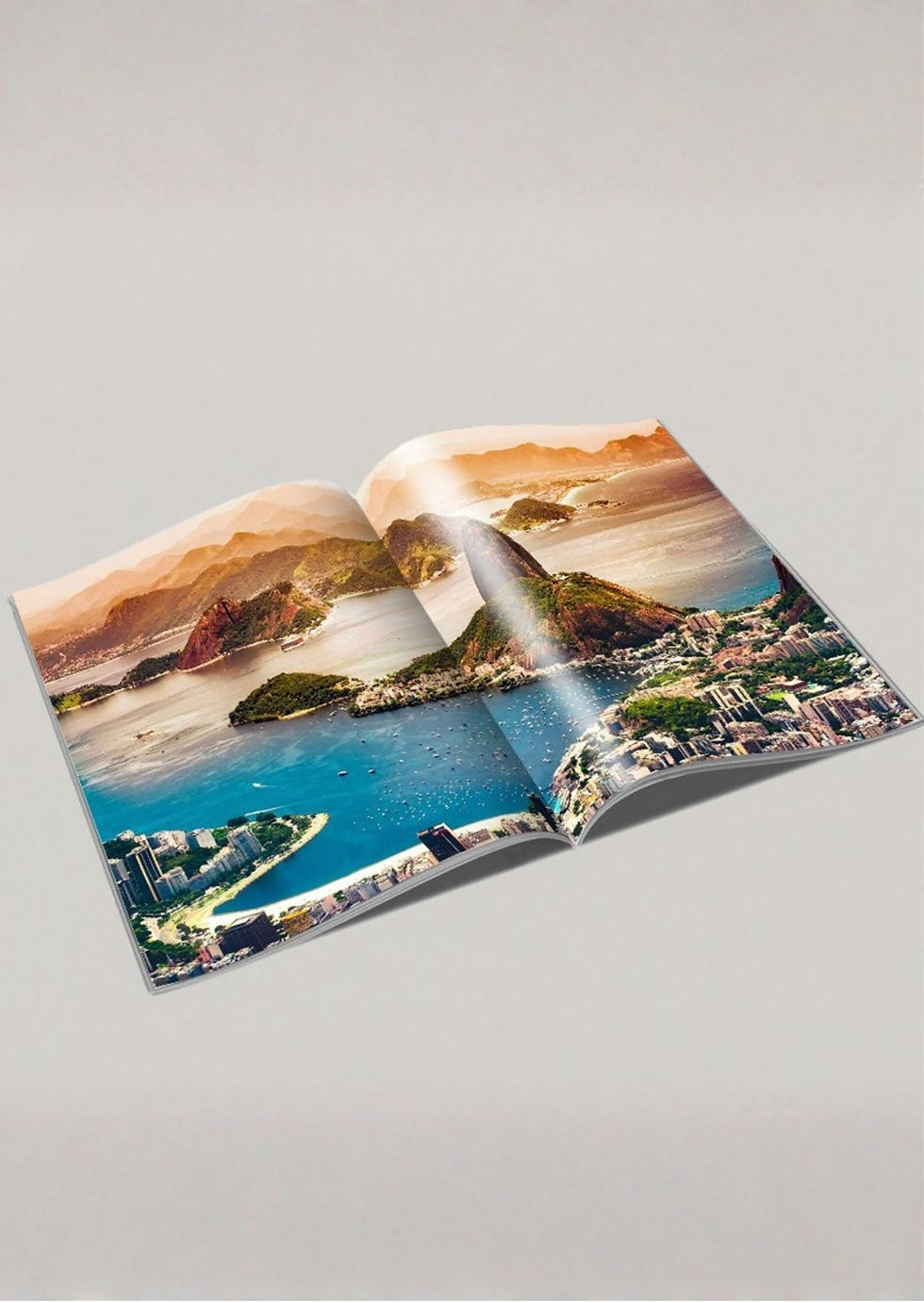 Miniatura: Quatro modelos de revistas de viagem personalizadas dispostas de forma organizada sobre uma mesa cinza moderna, mostrando cap
