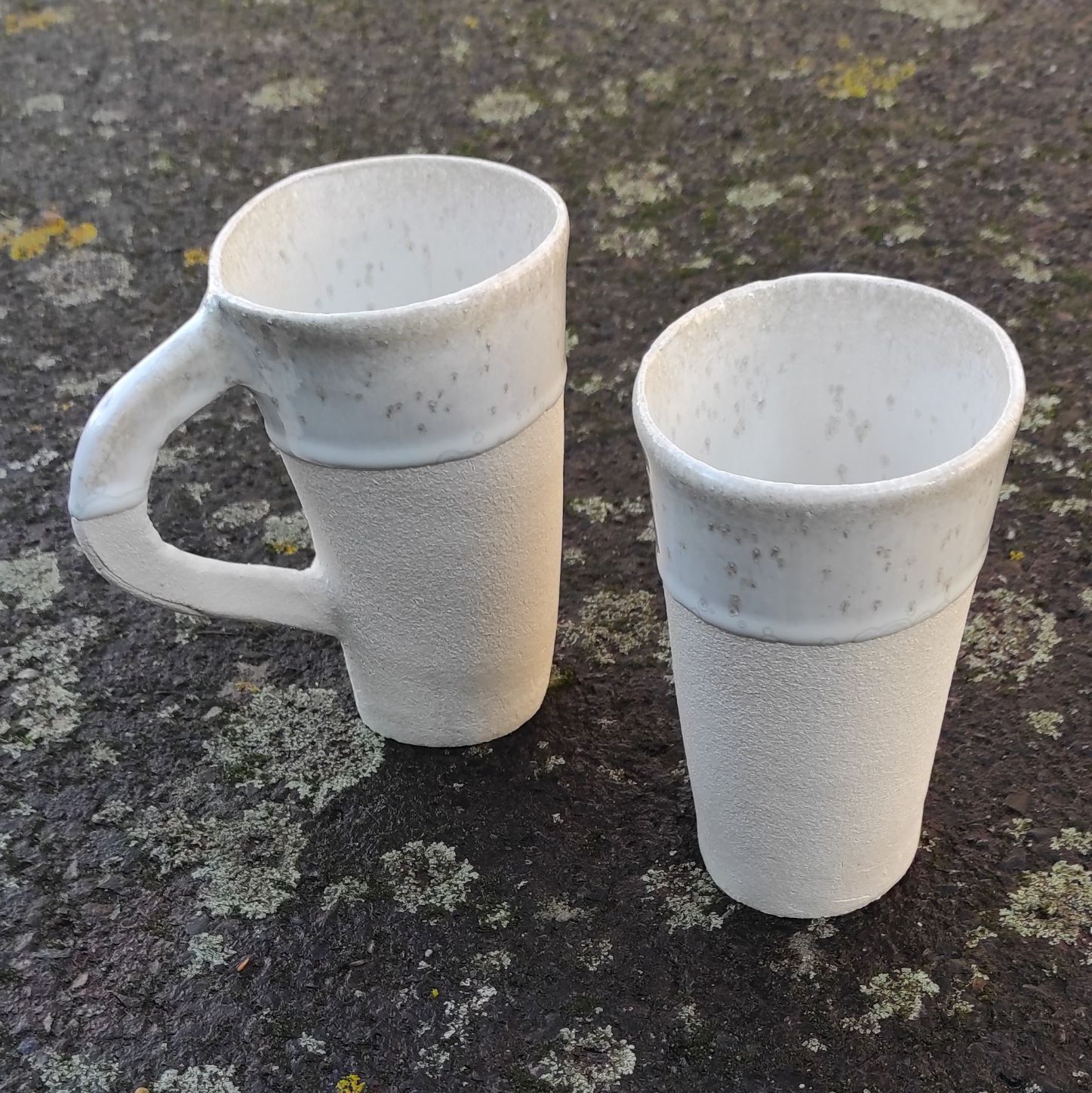 2 Gobelets artisanaux en  grès blanc émail  blanc avec cristallisations avec ou sans anse sur fond moucheté