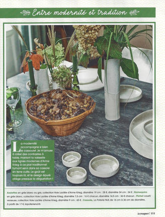 Vaisselle et vase Voie Lactée en grès blanc sur table disposée autour d'un plat de cassoulet