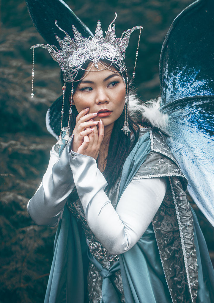 Asian model with silver headdress and fairy wings.