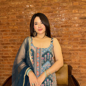 Me setting up our new style and business in a New colorful dress against brick wall background.