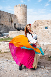 Vibrant solo traveler in colorful dress on a scenic hilltop