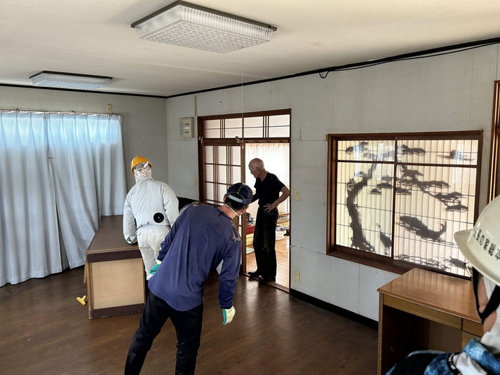 家屋の室内で片付け作業をする参加者