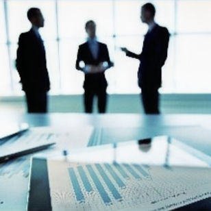 Three business people two men and a women communicating with a laptop in front
