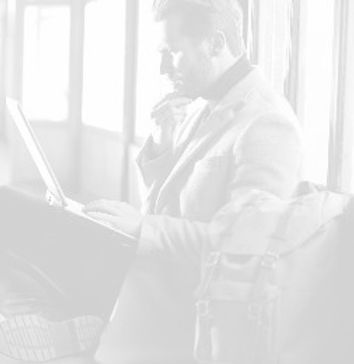 White man looking at laptop getting ready to travel