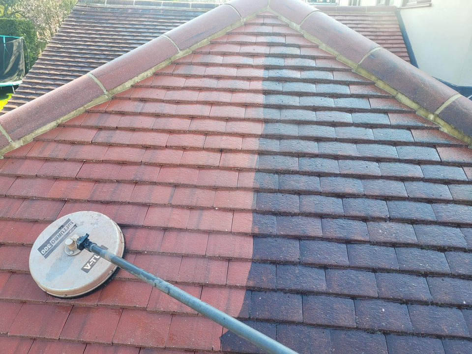 A side-by-side comparison showing a roof with dirty, moss-covered tiles next to the same roof after being professionally cleaned, looking bright and new.

