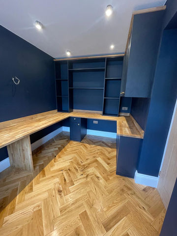 Custom-built home office with dark blue walls, integrated shelving, and oak worktops, designed for a Solihull property.