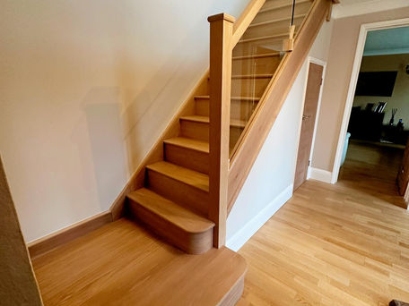 Handcrafted wooden staircase with glass balustrades, designed for a modern home in Leamington Spa.