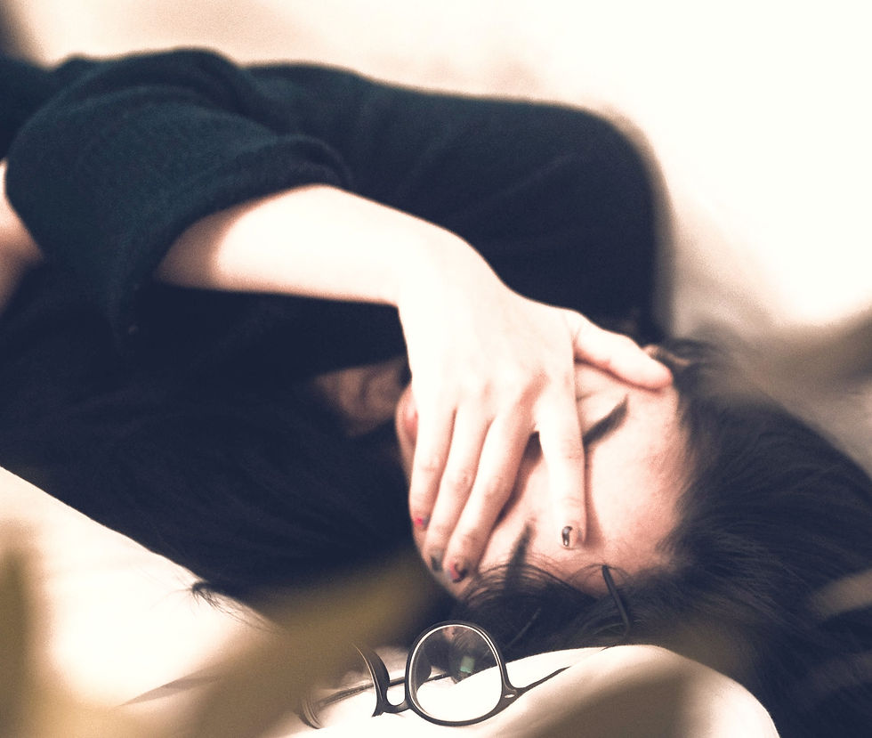 Lady covering her eyes laying down