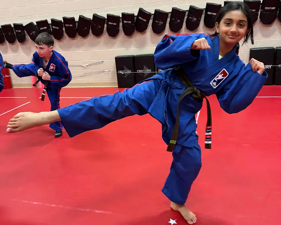 Two kids practice martial arts in a dojo. One child is smiling with confidence while performing a kid.