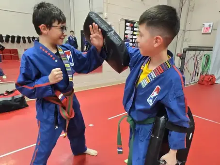 two students training together with padded hand targets