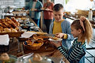 Happy kids having buffet breakfast while being with their parents in a hotel .jpg