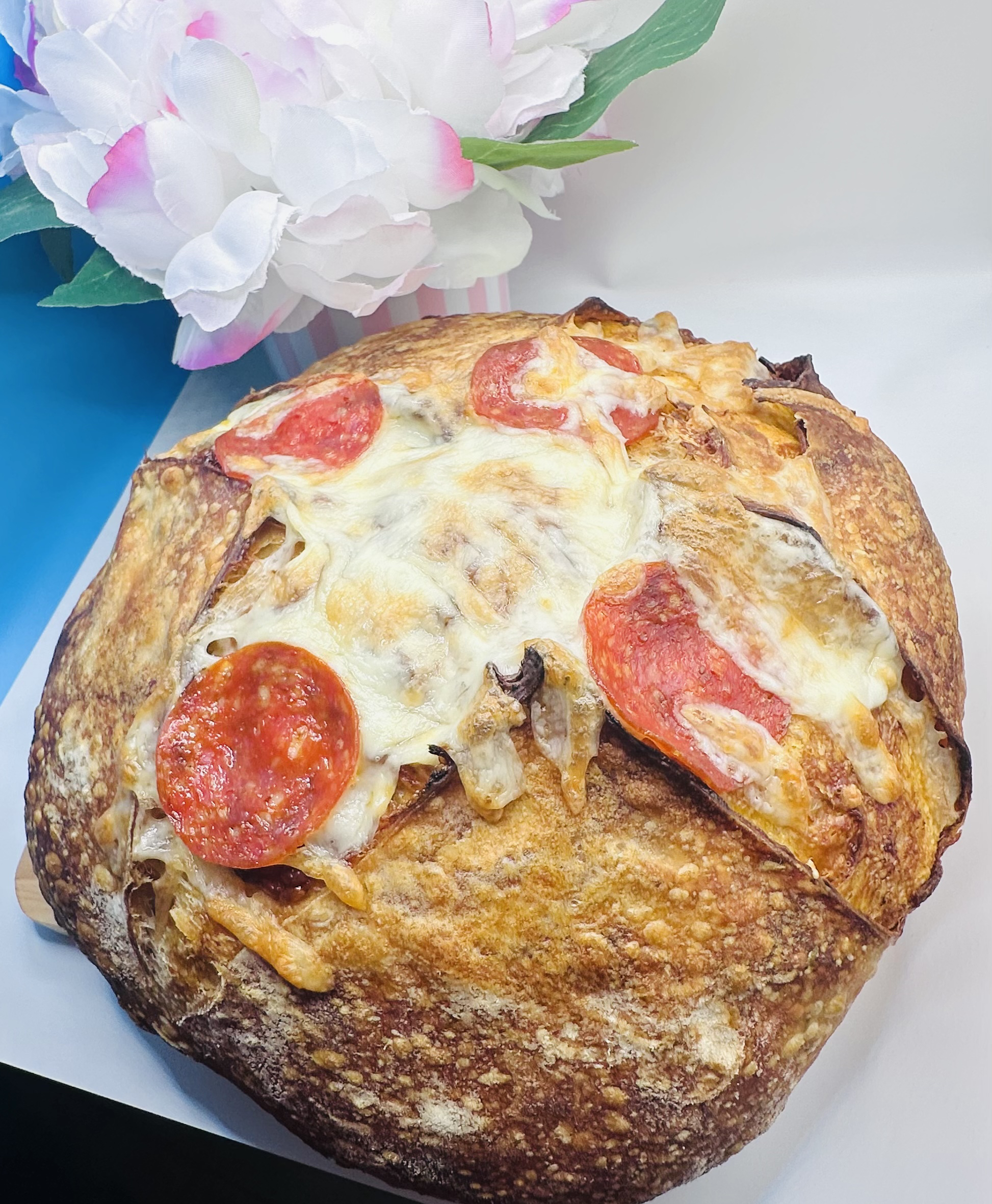 A freshly baked artisanal sourdough loaf with a perfectly golden and textured crust.