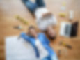 Husband and wife lying on the floor with blueprints and tools around them.