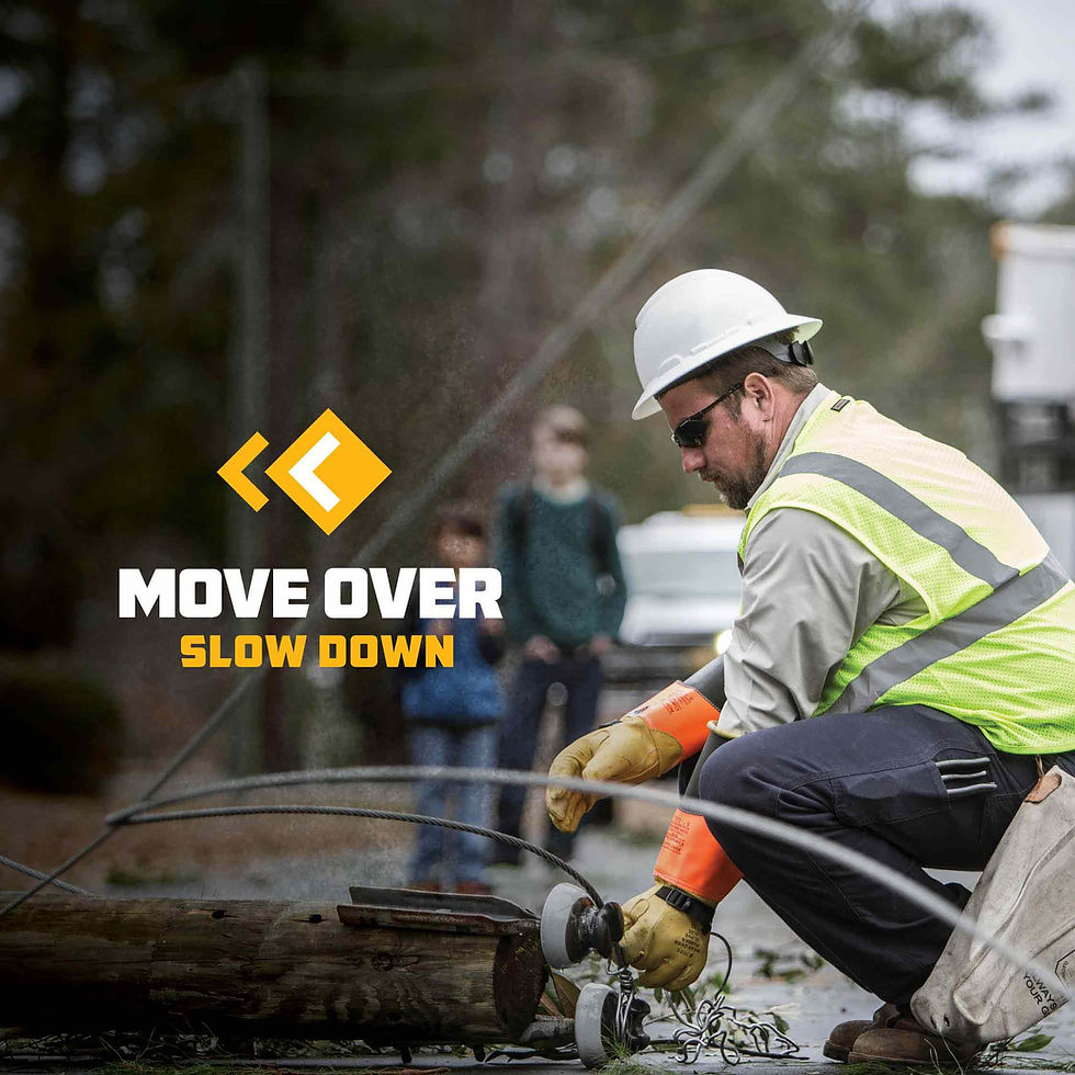 Photo of a line worker kneeling on a road, holding broken electric infrastructure.