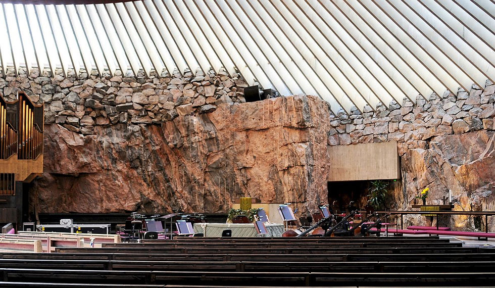 rows of church pews in front of a stage built out of a mountainous rock side