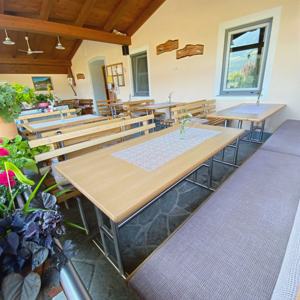 Gemütlicher Gastraum mit Holztischen und Bänken