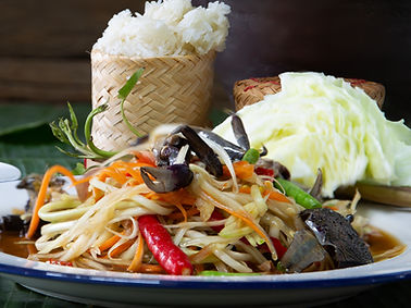 Papaya salad in white dish (Thai called Som tam) on fresh banana leaf, Choose focus and
