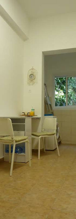 Маленькая комната со столом, стульями и видом на зелень.