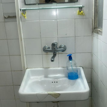 Белая раковина с краном и зеркалом