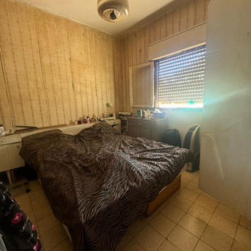 Спальня с кроватью, окном и деревянными стенами